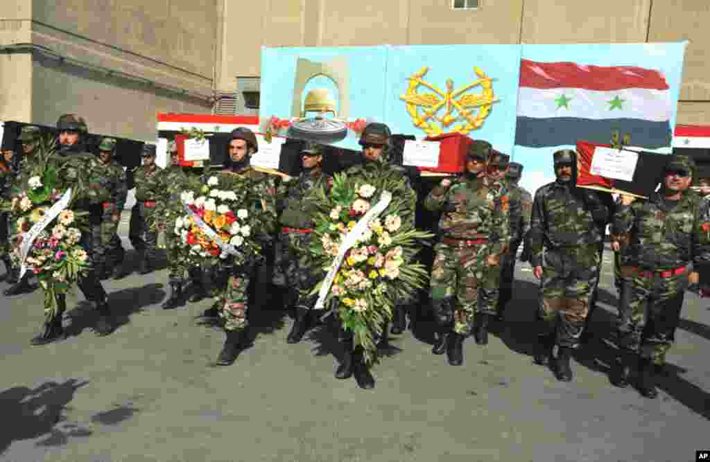 Syrian soldiers carry coffins of their colleagues during a funeral ceremony in Damascus, February 9, 2012. (Reuters)