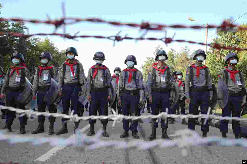 Police officers stand guard behind barbed wire as they attempt to stop protesters outside the Union Election Commission office in Naypyitaw, Myanmar. The military-backed main opposition party said it rejected last Sunday&#39;s election results, citing unfairn