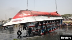 The ferry that collided with a cargo vessel and sank on Sunday in the Shitalakhsyaa River is pulled out from the river with a crane, during rescue operations in Narayanganj, Bangladesh, April 5, 2021. 