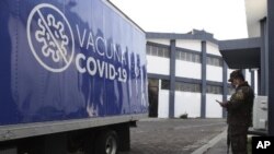 Un soldado está junto a un camión del Ministerio de Salud cargado con vacunas COVID-19 que el gobierno de El Salvador está donando y entregando a la vecina Honduras, antes de partir de San Salvador, El Salvador, el jueves 13 de mayo de 2021.