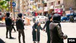 Polícia protege uma religiosa copta, na cidade de Tanta, Egipto, 20 de Maio, 2017.