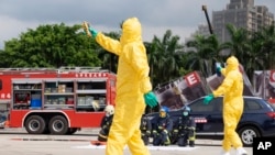 Firefighters in protection suits take part in drills simulating a power plant explosion in New Taipei City, Taiwan on July 14, 2022.