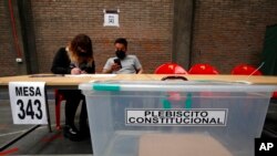 Poll workers prepare for a referendum vote on the draft of a new constitution, at a polling station in Santiago, Chile, Sept. 3, 2022.