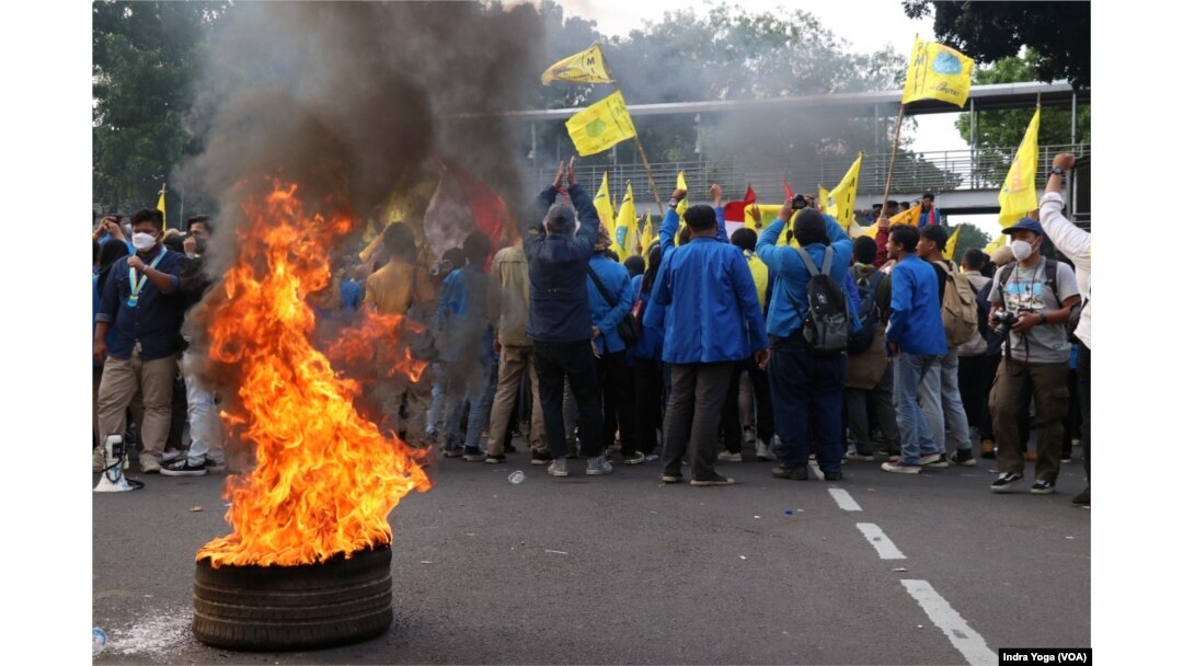 Demonstran membakar keranda di dekat pagar kawat berduri yang dipasang aparat keamanan, dalam aksi unjuk rasa di Patung Kuda, Medan Merdeka Barat, Jakarta, (5/9). (VOA/Indra Yoga)