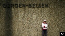 Israeli Olympic race walker Shaul Ladany poses for a photo at the entrance of the Nazi concentration camp Bergen-Belsen in Bergen, Germany, Sept. 3, 2022. 