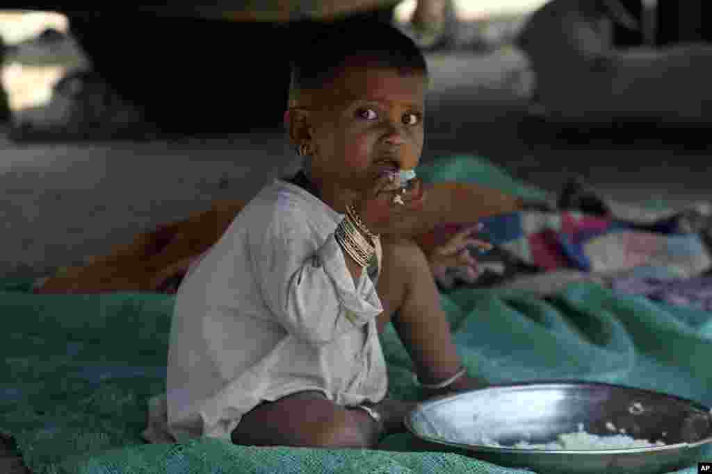 A young victim of the flooding from monsoon rains receives food from the Alkhidmat Foundation, in Jaffarabad, Pakistan, Sept. 5, 2022.
