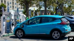 FILE: Electric vehicles can be seen charging at a shopping center. Taken Aug. 10, 2022. 