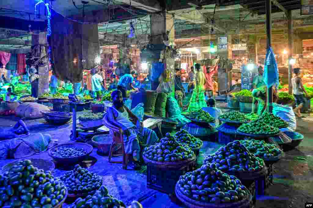 Vendors wait for customers at a wholesale vegetable market in Dhaka, Bangladesh.