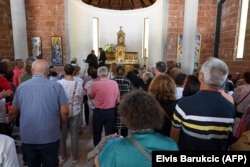 Umat Katolik Bosnia berkumpul untuk berdoa selama upacara pembukaan gereja Katolik yang baru dibangun di Bugojno, pada 2 Agustus 2022. (Foto: AFP/Elvis Barukcic)