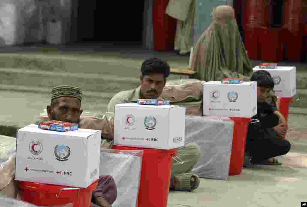 Flooding victims get aid from the International Federation of Red Cross and Red Crescent Societies in Charsadda, Pakistan, Sept. 5, 2022.