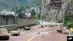 In this photo provided by China's Xinhua News Agency, fallen rocks are seen on a road near Lengqi Town in Luding County of southwest China's Sichuan Province, Sept. 5, 2022. (Xinhua via AP)