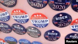  FILE - Biden for President campaign buttons are for sale beside "Impeach Trump Now!" buttons as U.S. Democratic presidential candidate and former Vice President Joe Biden meets union workers at the Teamsters Local 249 hall in Pittsburgh, April 29, 2019.