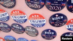 Lencana kampanye presiden Joe Biden dijual bersama dengan lencana bertuliska "Makzulkan Trump Sekarang!" saat capres dari partai Demokrat, Biden bertemu serikat pekerja di Pittsburgh, 29 April 2019.