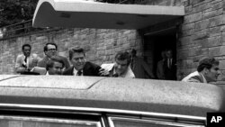 FILE - In this March 30, 1981, photo, U.S. president Ronald Reagan, center, is shown being shoved into his limousine by secret service agents after being shot by John Hinckley outside a Washington, D.C., hotel.