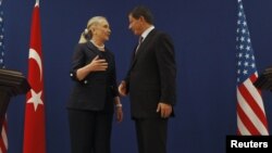 U.S. Secretary of State Hillary Clinton and Turkish Foreign Minister Ahmet Davutoglu talk after their news conference in Istanbul, Turkey, August 11, 2012.