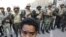 An Egyptian protester boy stands in front of army soldiers who try to lead the protesters away from Tahrir Square in Cairo, Egypt Sunday morning, Feb. 13, 2011. Egypt's military took down the makeshift tents of protesters who camped out on the square in a