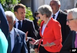 French President Emmanuel Macron, left, talks with British Prime Minister Theresa May when arriving for a family photo at the informal EU summit in Salzburg, Austria, Sept. 20, 2018.