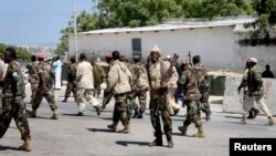 Somali soldiers patrol at the front gate of the presidential palace following a suicide bomb attack in Mogadishu, Somalia, January 29, 2013. 