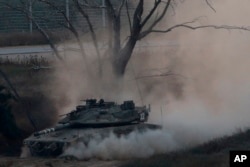 An Israeli tank drives along the border with the Gaza strip, on the Israel-Gaza border, May 29, 2018.