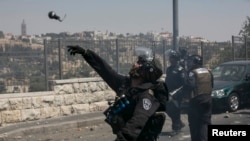 이스라엘 경찰이 5일 팔레스타인 시위대에 최루탄을 던치고 있다.