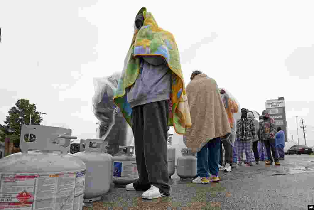 People wait in line in the freezing rain to fill their propane tanks in Houston, Texas. Millions in Texas still had no power after a historic snowfall and single-digit temperatures created a surge of demand for electricity to warm up homes unaccustomed to such extreme lows.