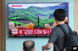 FILE - People watch news images of a reported launch of a North Korean Hwasong-14 intercontinental ballistic missile, at Seoul Train Station in Seoul, South Korea, July 4, 2017. The threat of Pyongyang's nuclear and missile programs are expected to be high on President Donald Trump's agenda during his November 3-14 trip to Asia.