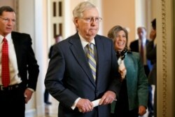 Senate Majority Leader Mitch McConnell of Ky., center, walks to the podium with Sen. John Barrasso, R-Wyo., left, and Sen. Joni Ernst, R-Iowa, Oct. 29, 2019, on Capitol Hill in Washington.