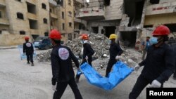 Trabajadores de rescate llevan un cuerpo en Raqqa, Siria, 9 de abril de 2018. Reuters