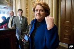 FILE - In this Jan. 22, 2018 file photo, Sen. Heidi Heitkamp, D-N.D., leaves a meeting with fellow Democrats at the Capitol in Washington.