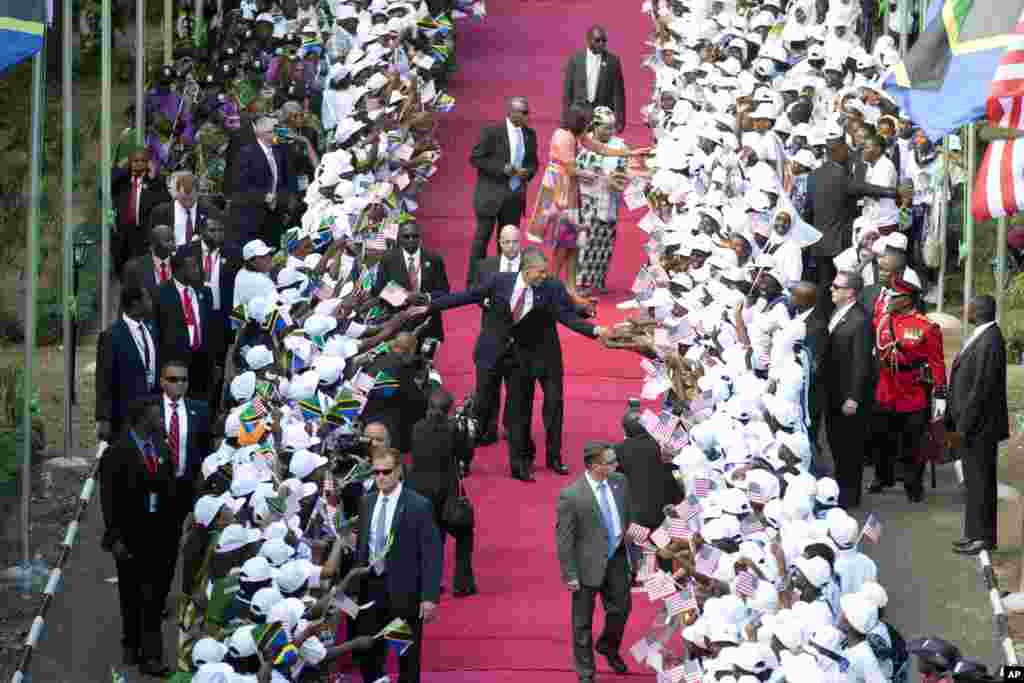 President Barack Obama and Tanzanian President Jakaya Kikwete walk in front of Michelle Obama and Salma Kikwete as they arrive at the State House in Dar es Salaam, Tanzania, July 1, 2013.