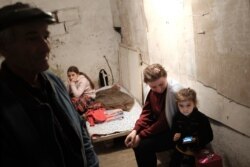People with their children sit in a bombshelter to protect against shelling in Stepanakert, the self-proclaimed Republic of Nagorno-Karabakh, Azerbaijan, Sept. 28, 2020. (ArmGov/PAN Photo via AP)