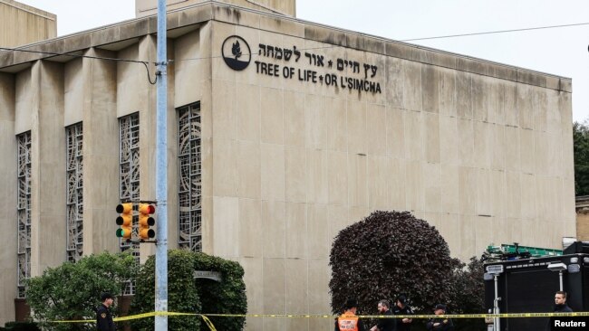 Police officers guard the Tree of Life synagogue following shooting at the synagogue in Pittsburgh, Pa, Oct. 27, 2018.