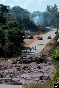 Un camino es bloqueado por lodo y otros residuos provenientes de una presa de relaves cerca de Brumadinho, Brasil, el viernes 25 de enero de 2019.