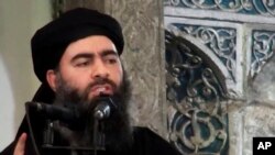 FILE - This image from a militant website in July 2014 purports to show IS leader Abu Bakr al-Baghdadi at a mosque in Iraq. Hajji Abd al-Nasir, an al-Baghdadi confidant, has now been named a specially designated global terrorist by the U.S.