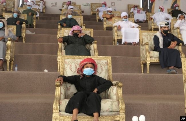 Emirati camel breeder families watch as the competition winners are decided at Al Dhafra Festival in Liwa desert area 120 kilometres southwest of Abu Dhabi, United Arab Emirates, Wednesday, Dec. 22, 2021. (AP Photo/Isabel DeBre)