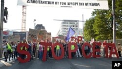 FILE - Protestors hold an anti-CETA banner during a demonstration against international trade agreements, in Brussels. 
