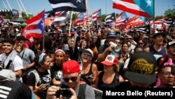 People chant slogans as they wave Puerto Rican flags during a protest calling for the resignation of Governor Ricardo Rossello in San Juan, Puerto Rico July 22, 2019. (REUTERS/Marco Bello)