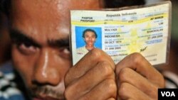 Seorang pekerja Indonesia menunjukkan kartu identitasnya menunggu pemeriksaan imigrasi di Klang, di pinggiran Kuala Lumpur (foto: dok.)