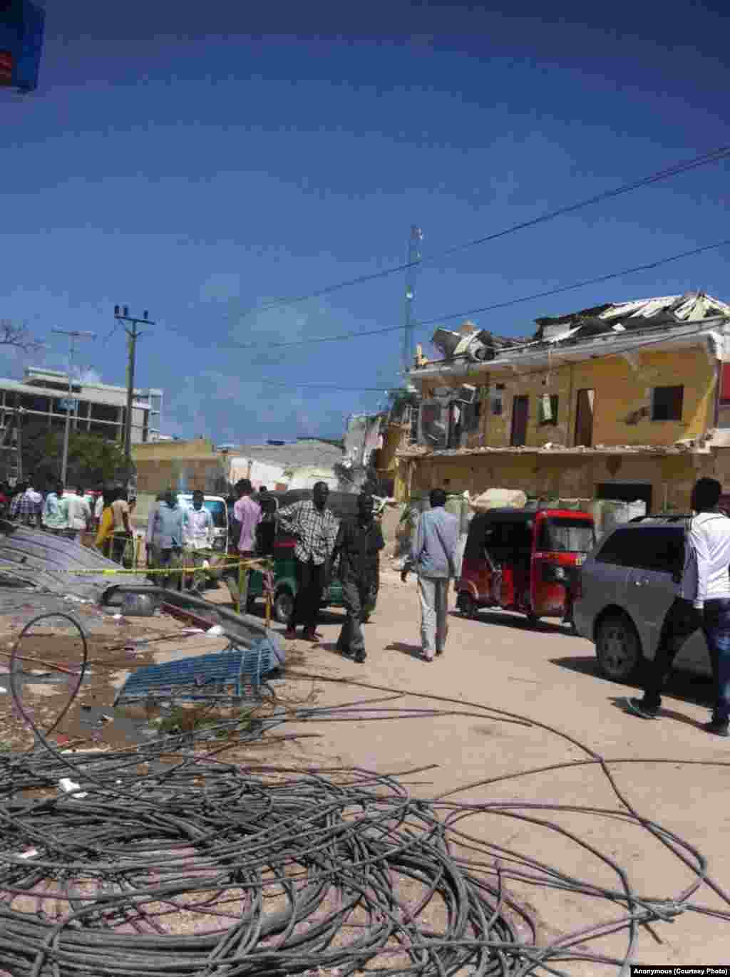 Somalis walk around the neighborhood of the destroyed Naso Hanlod hotel.