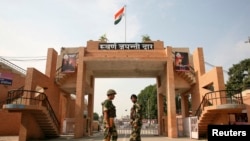India's Border Security Force (BSF) soldiers patrol in front of the golden jubilee gate at the Wagah border, on the outskirts of the northern Indian city of Amritsar, Nov. 3, 2014. 