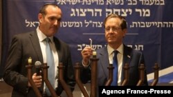 Israeli President Isaac Herzog, right, lights a menorah to mark the Jewish holiday of Hanukkah at the Ibrahimi mosque, also known as the Cave of the Patriarchs, in the divided West Bank city of Hebron, Nov. 28, 2021.