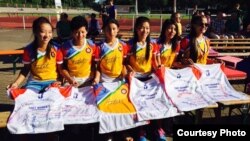 The Tibet Women's Soccer team signs autographs on jerseys, in Berlin, Germany, for the Discover Football event, June 30, 2015. 