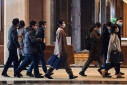 Chinese officials arrive for meetings with the World Health Organization team investigating the origins of the COVID-19 pandemic at the Hilton Wuhan Optics Valley Hotel in Wuhan, Jan. 29, 2021.