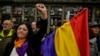 FILE - A woman holds up her left fist beside to a Spanish Republican flag during a tribute 46 unidentified people killed during the Spanish Civil War, at San Jose cemetery, Pamplona, northern Spain, April 1, 2019.