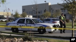 Un funcionario policial detiene un vehículo en un punto de control frente al centro de distribución de FedEx donde una explotó un paquete el martes, 20 de marzo, de 2018, en Schertz, Texas.