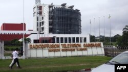 Les gens passent devant les locaux de la radiodiffusion et télévision gabonaise, à Libreville, le 16 juin 2017.