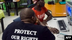 FILE - An outreach officer shares some of her experiences with a visitor at the local charity Gender Dynamix, at its offices in Athlone, near Cape Town, South Africa, Nov. 16, 2012. Botwana recently followed South Africa in allowing a gender identity change. 