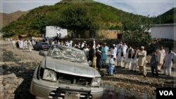 Warga mengerumuni lokasi kejadian bom yang menewaskan mantan pejabat senior Pakistan (7/11).