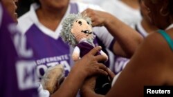 Supporters of Mexican presidential candidate Andres Manuel Lopez Obrador hold a doll resembling him, while gathering at the country's largest soccer stadium for his closing campaign rally, in Mexico City, June 27, 2018.