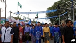 Perdana Menteri Malaysia Najib Razak (tengah) dan kandidat lainnya tiba di pusat nominasi pemilu di Pekan, negara bagian Pahang (20/4). (AP/Lai Seng Sin)